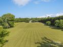 Aerial view of the expansive property featuring lush green lawns and mature trees at 130 Johnson Dairy Rd, Rockwell, NC 28138