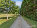 Picturesque gravel driveway lined with mature trees leading to the property at 130 Johnson Dairy Rd, Rockwell, NC 28138