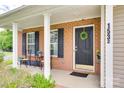 Inviting brick front porch with black shutters, a dark-colored front door, and decorative accents at 1532 Andora Dr, Rock Hill, SC 29732