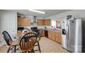 Kitchen with wooden cabinets, tile flooring, black appliances, and a stainless steel refrigerator at 1532 Andora Dr, Rock Hill, SC 29732