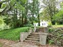 Stone steps leading to the front yard, enveloped by verdant greenery and mature trees at 206 Rose Ter, Wadesboro, NC 28170