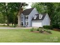 Charming two-story home featuring a spacious lawn, two car garage, and well-maintained landscaping at 211 Southfork Dr, Belmont, NC 28012