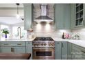 Modern kitchen with stainless steel appliances, stone backsplash, quartz countertops, and sage cabinets at 211 Southfork Dr, Belmont, NC 28012
