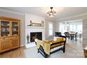 Cozy living room featuring a fireplace, hardwood floors, with adjacent dining room for seamless entertaining at 211 Southfork Dr, Belmont, NC 28012