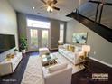 Staged living room showcasing a white sofa set, area rug, and dark hardwood floors at 2125 Southend Dr # 320, Charlotte, NC 28203