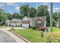 Charming single-story brick home with a well-maintained lawn and attached two-car garage in a neighborhood at 2333 Wednesbury Ct, Kannapolis, NC 28083
