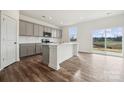 Modern kitchen with gray cabinets, white countertops, stainless steel microwave, and wood-look flooring at 2592 Blue Sky Meadows Dr, Monroe, NC 28110