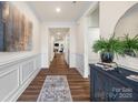 Long hallway with decorative wainscoting and hard wood floors at 2658 Manor Stone Way, Indian Trail, NC 28079