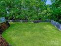 A large, lush green backyard is enclosed by a white picket fence, offering both privacy and aesthetic appeal at 2725 Cotton Planter Ln, Charlotte, NC 28270