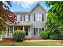 Charming two-story home featuring gray siding, black shutters, front porch and manicured landscaping at 2725 Cotton Planter Ln, Charlotte, NC 28270
