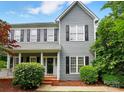 Charming two-story home featuring gray siding, black shutters, manicured landscaping and covered front porch at 2725 Cotton Planter Ln, Charlotte, NC 28270