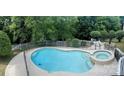 Aerial view of fenced kidney-shaped swimming pool and hot tub surrounded by lounge chairs and dining at 2725 Cotton Planter Ln, Charlotte, NC 28270