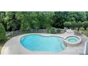 Aerial view of fenced kidney-shaped swimming pool and hot tub surrounded by lounge chairs and dining at 2725 Cotton Planter Ln, Charlotte, NC 28270