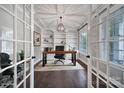 Modern office space with a wooden desk, built-in bookshelves, large windows, and a stylish light fixture at 295 Helton Ln, Fort Mill, SC 29708