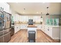 Bright kitchen featuring white cabinets, stainless steel appliances, butcher block island, and wood flooring at 3020 Quiet Ln, Iron Station, NC 28080
