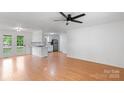 Bright living room with hardwood floors and access to kitchen; features a ceiling fan and white walls at 3103 Suggs St, Belmont, NC 28012