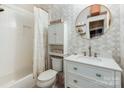 Bathroom with a white vanity, round mirror, decorative tiling, and a shower-tub combination at 3308 Selwyn Farms Ln # 2, Charlotte, NC 28209