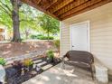 Covered patio area with a wicker bench, landscaped garden, and a view of the yard at 3308 Selwyn Farms Ln # 2, Charlotte, NC 28209