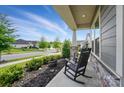 Relaxing front porch view with rocking chairs and stone pillar details, perfect for enjoying the neighborhood at 3833 Isenhour Rd, Kannapolis, NC 28081