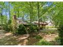 Wood and stone home is surrounded by a mature forest, creating a peaceful and private setting at 4417 Walter Nelson Rd, Mint Hill, NC 28227