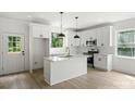 Bright kitchen with white cabinets, island with pendant lighting, and stainless steel appliances at 4541 Kings Ct, Hickory, NC 28602