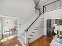 Spacious foyer featuring a staircase with elegant banister, chandelier, and hardwood floors at 5308 Sunningdale Dr, Charlotte, NC 28277