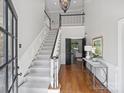 Bright foyer with a soaring staircase, hardwood floors, and elegant chandelier at 5308 Sunningdale Dr, Charlotte, NC 28277