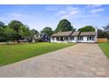 Well-maintained single-story home with a spacious driveway and lush greenery at 554 Isle Of Pines Rd, Mooresville, NC 28117