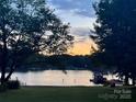 Beautiful waterfront view with dock and glistening water in the evening at 554 Isle Of Pines Rd, Mooresville, NC 28117