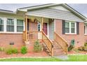 Close-up of the front porch with wooden railings, brick steps, and colorful hanging flower baskets at 622 University Dr, Rock Hill, SC 29730