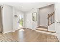 Bright and inviting foyer with hardwood floors, staircase, and a glass-paneled front door at 625 Uwharrie River Rd, Charlotte, NC 28211