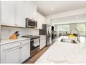 Bright, modern kitchen featuring white cabinetry, stainless steel appliances, and a marble countertop at 625 Uwharrie River Rd, Charlotte, NC 28211