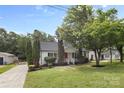 Traditional home with manicured lawn, mature trees, and a detached garage on a spacious lot at 6412 Sullins Rd, Charlotte, NC 28214