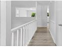 Bright hallway with wood floors, white railing, and neutral tones for a modern, airy feel at 6412 Sullins Rd, Charlotte, NC 28214