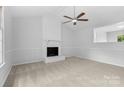 Inviting living room featuring a brick fireplace, ceiling fan, and ample natural light for a cozy atmosphere at 6412 Sullins Rd, Charlotte, NC 28214