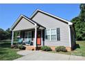 Inviting home with a covered front porch, stylish siding, and neat landscaping at 650 Harry St, China Grove, NC 28023