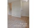 Bright living room featuring freshly painted walls, brand new hardwood flooring, and updated trim at 6921 Idlewild Rd, Charlotte, NC 28212
