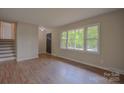 Bright living room featuring freshly painted walls, brand new hardwood flooring, and updated trim at 6921 Idlewild Rd, Charlotte, NC 28212