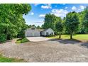 Charming single-Gathering home with a two-car garage sits on a gravel lot with mature trees and a pristine lawn at 6992 Sherrills Ford Rd, Sherrills Ford, NC 28673