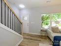 Welcoming foyer showcasing wood-look floors, stairway access, and natural lighting at 8611 Earthenware Dr, Charlotte, NC 28269