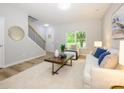 Cozy living room with wood-look flooring, a front-entry door and staircase access at 8611 Earthenware Dr, Charlotte, NC 28269