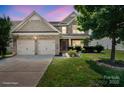 Charming two-story home featuring a two-car garage, landscaped yard, and a mix of brick and siding accents at 10211 Snowbell Ct, Charlotte, NC 28215