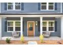 Inviting front porch with neutral furniture, modern door, and exterior lighting at 1025 Harrogate Dr, Bessemer City, NC 28016