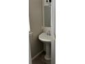 Compact powder room with pedestal sink, window, and a neutral color palette at 10826 Claude Freeman Dr, Charlotte, NC 28262