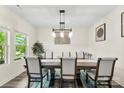 Bright dining room with modern lighting fixture, large window, and stylish decor, perfect for Gathering meals at 11518 Solstice Way, Huntersville, NC 28078