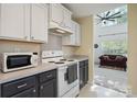 A cozy kitchen features white upper cabinets, contrasting dark lower cabinets, and modern appliances at 1457 Matthew Allen Cir, Kannapolis, NC 28081