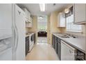 Galley kitchen features white appliances, plenty of cabinet space and a stainless steel sink at 1457 Matthew Allen Cir, Kannapolis, NC 28081
