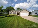 Charming single-story home featuring a well-manicured lawn and an attached two-car garage under a bright sky at 1505 Moss Springs Rd, Albemarle, NC 28001