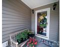 Cozy front porch decorated with a bench, potted plants and seasonal decor on the door at 1505 Moss Springs Rd, Albemarle, NC 28001