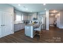 Modern kitchen with an island, granite countertops, stainless steel appliances, and sleek gray cabinetry at 177 Willow Valley Dr, Mooresville, NC 28115